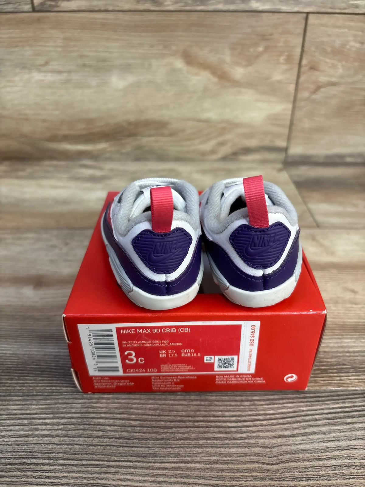 Rear view of Nike Air Max 90 crib sneakers size 3C showing purple heart heel logos, white and grey upper, and pink pull tabs on a red Nike shoebox