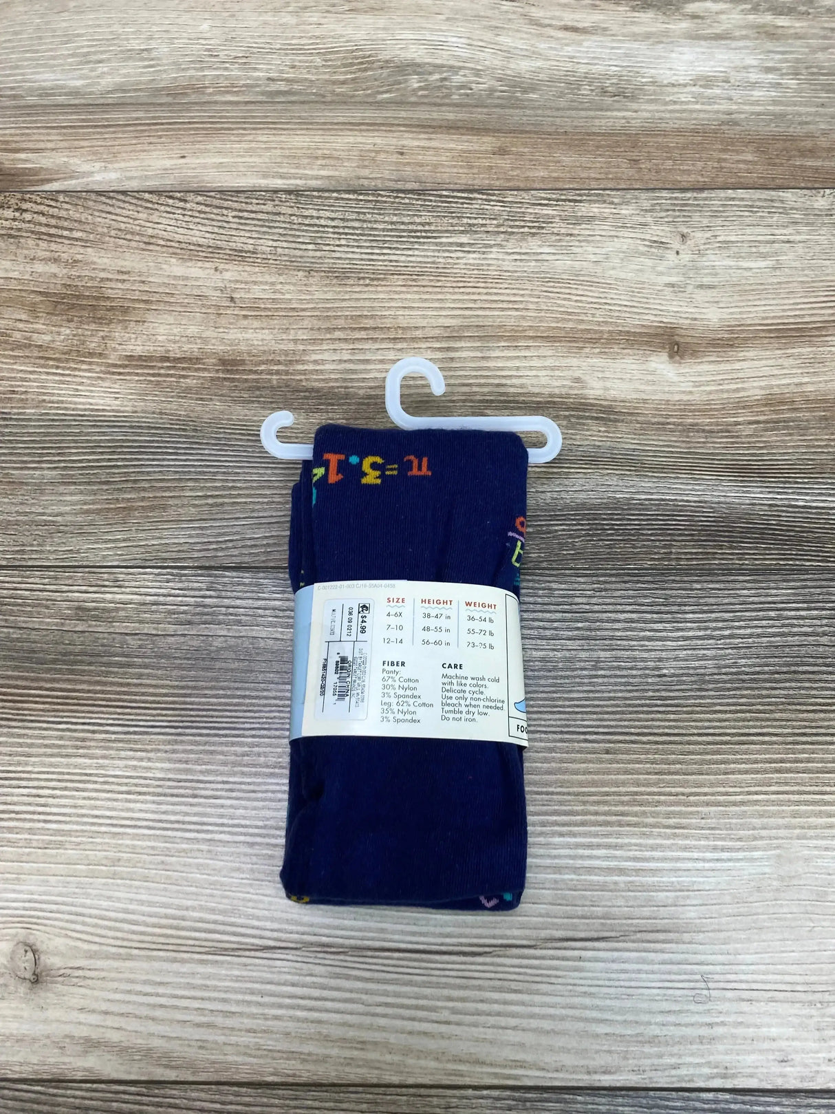 Front view of navy Cat and Jack tights size 12-14 with colorful math symbol pattern and label on light wood background