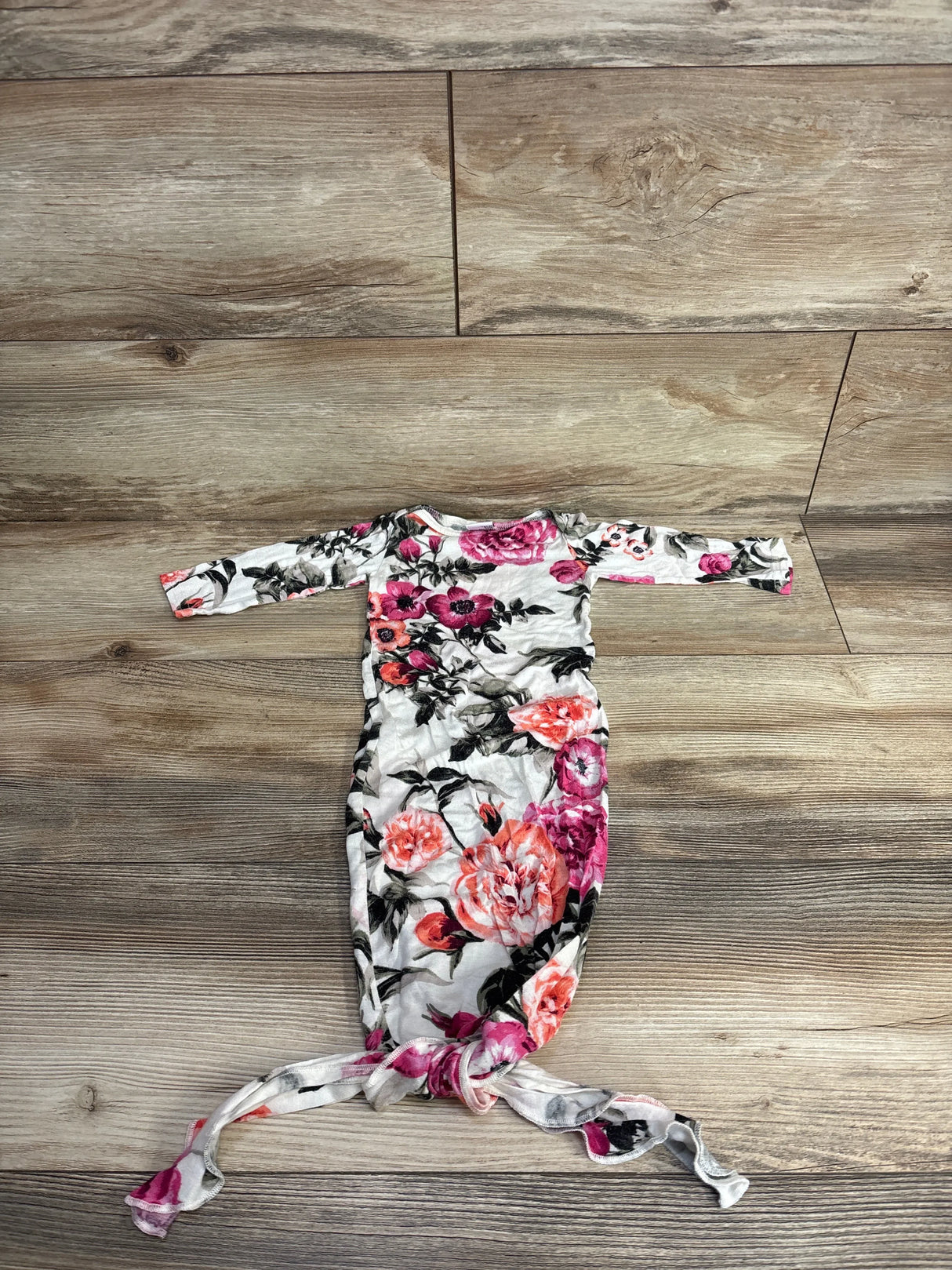 Floral newborn knotted gown with long sleeves on wood background