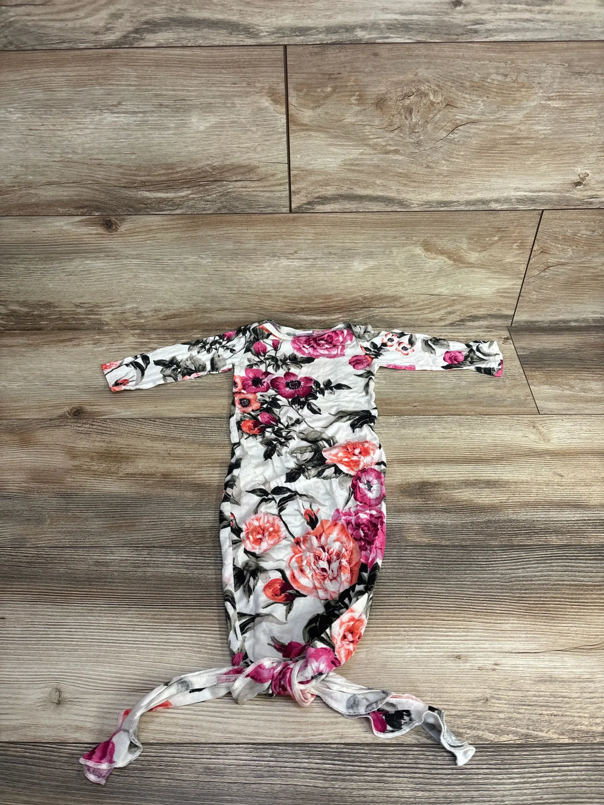 Floral newborn knotted gown with long sleeves on wood background