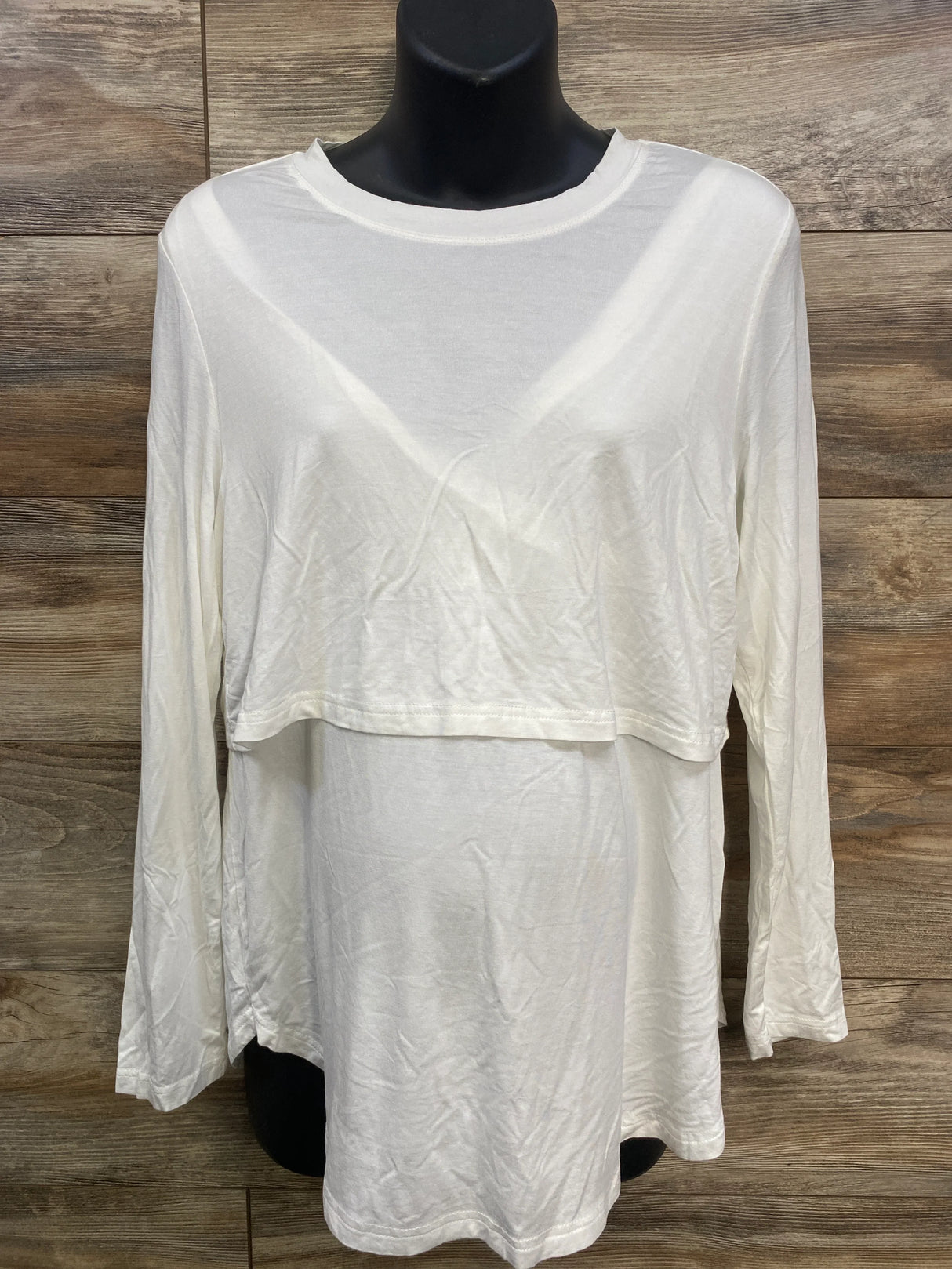 White long sleeve layered maternity top on black mannequin against wood background