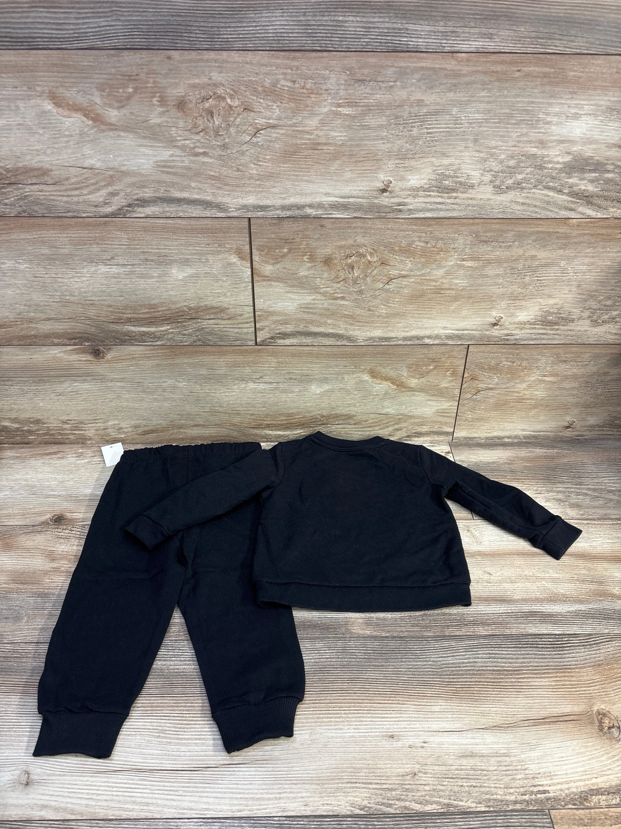 Back view of Cat and Jack 2-piece toddler sweatshirt and joggers showing elastic waistband and ribbed cuffs on wood background