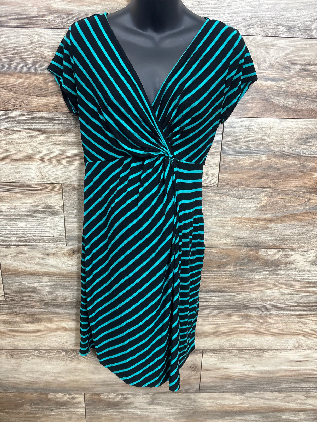 Black and teal striped wrap dress on mannequin against wooden background