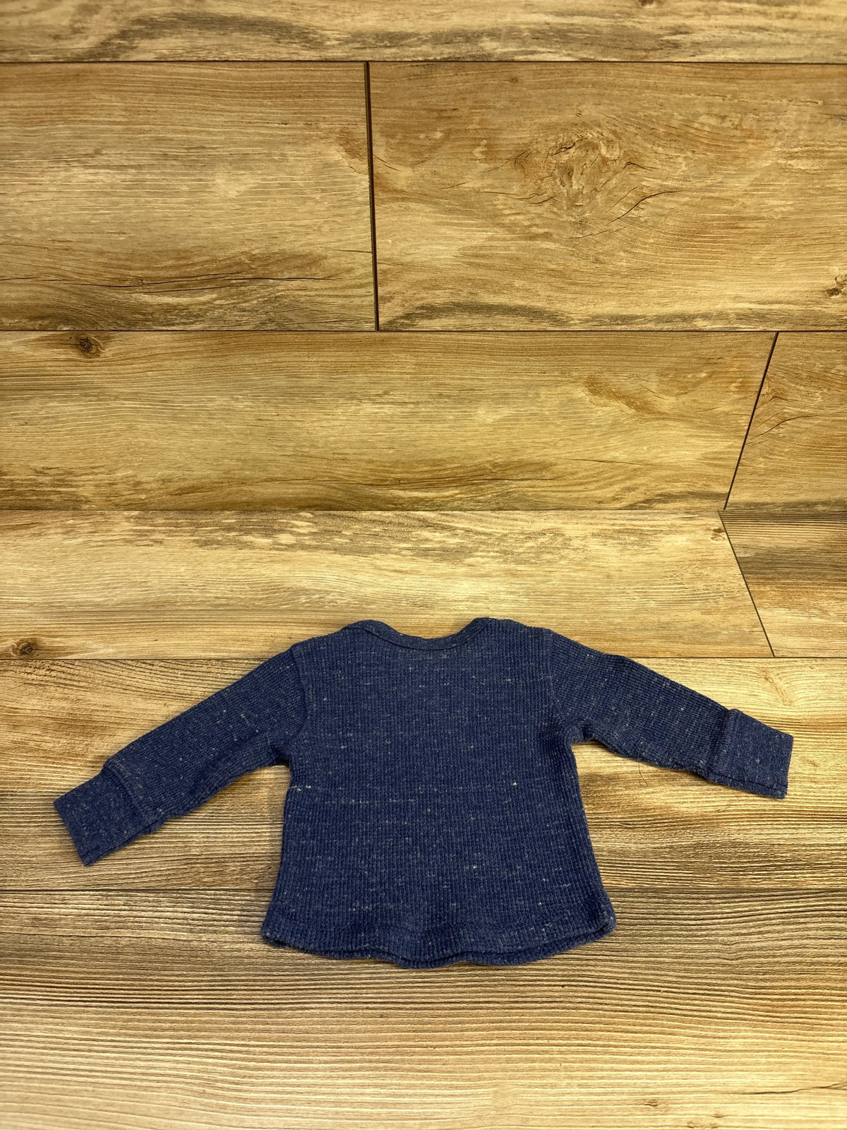 Flat view of Okie Dokie waffle knit shirt in navy, size 3 months, showing long sleeves and textured knit on a wood background