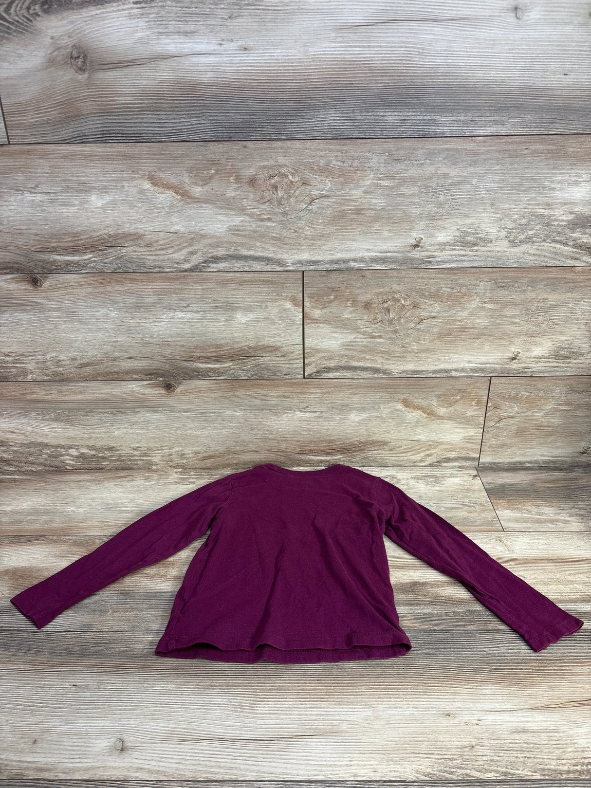 Back view of Baby Gap maroon long-sleeve toddler shirt size 5T showing solid color and crew neckline on wood floor background