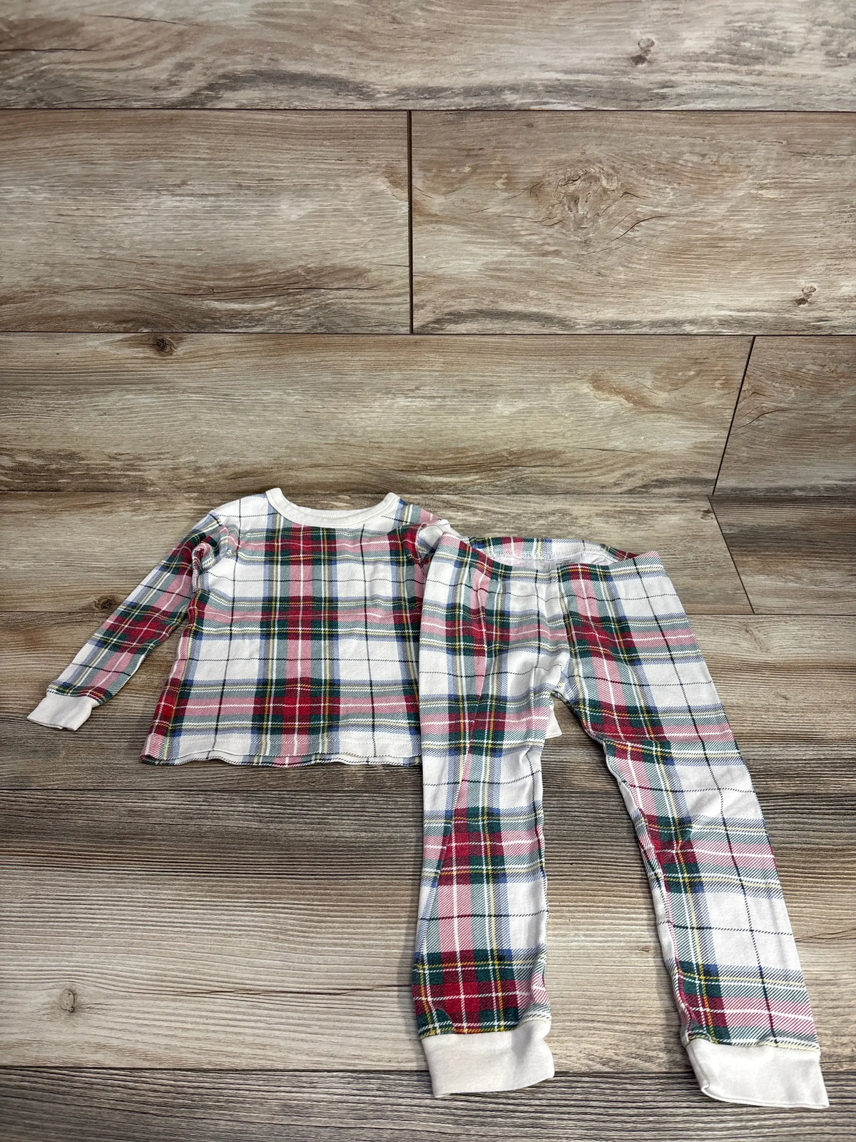 Kids plaid pajama set with red, green, and blue pattern on wood floor