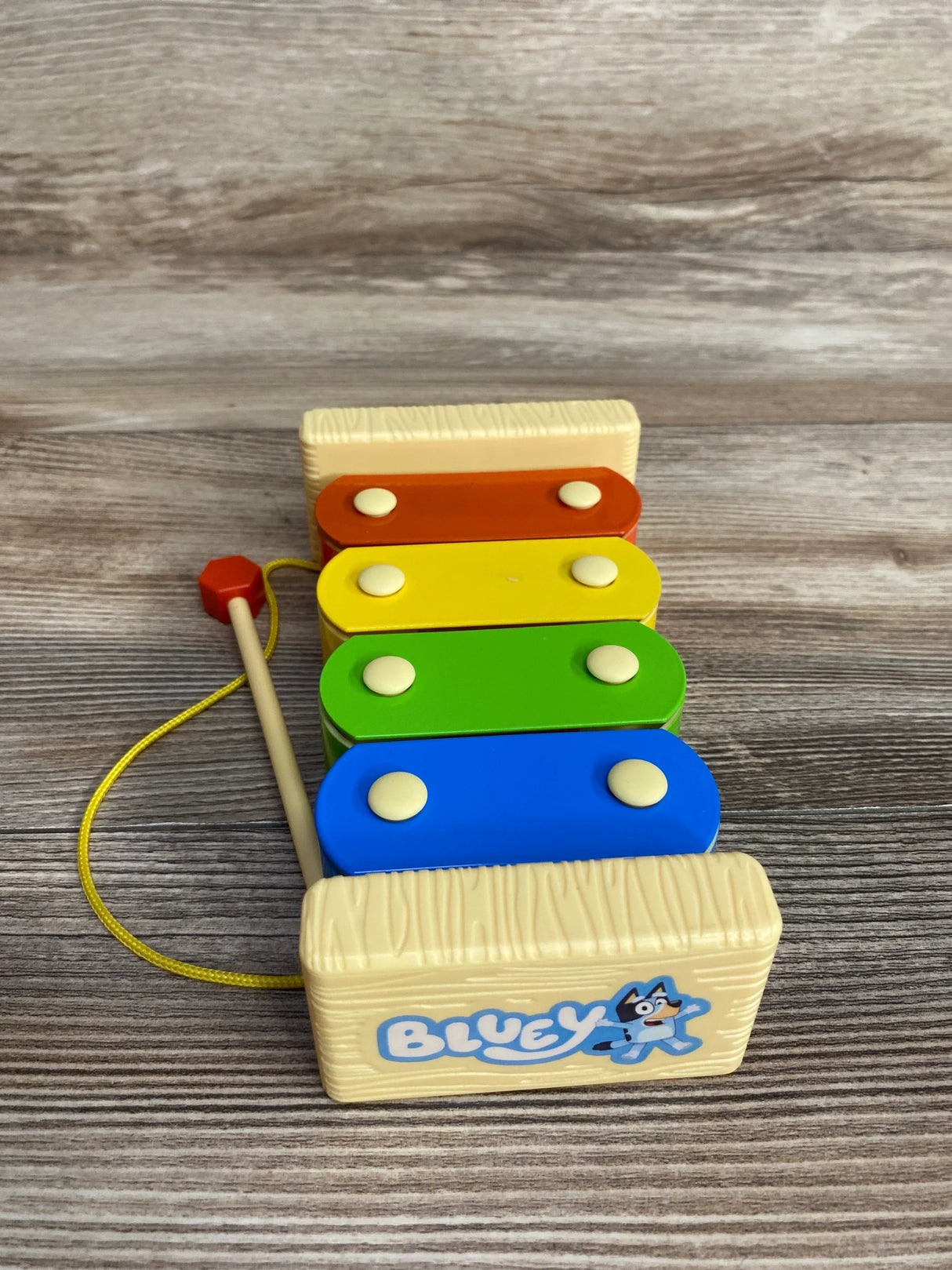 Bluey wooden xylophone toy for kids with colorful bars and mallet on wood surface