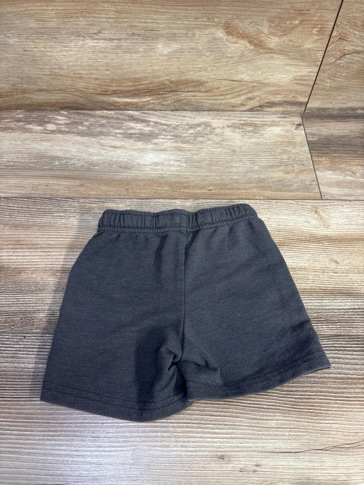 Flat lay of Cat & Jack toddler grey knit shorts showing elastic waistband and straight leg on wood background