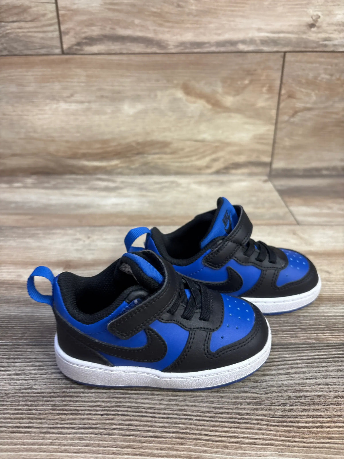 Three-quarter view of Nike Court Borough Recraft TD sneakers in Game Royal and Black, showing hook-and-loop closures