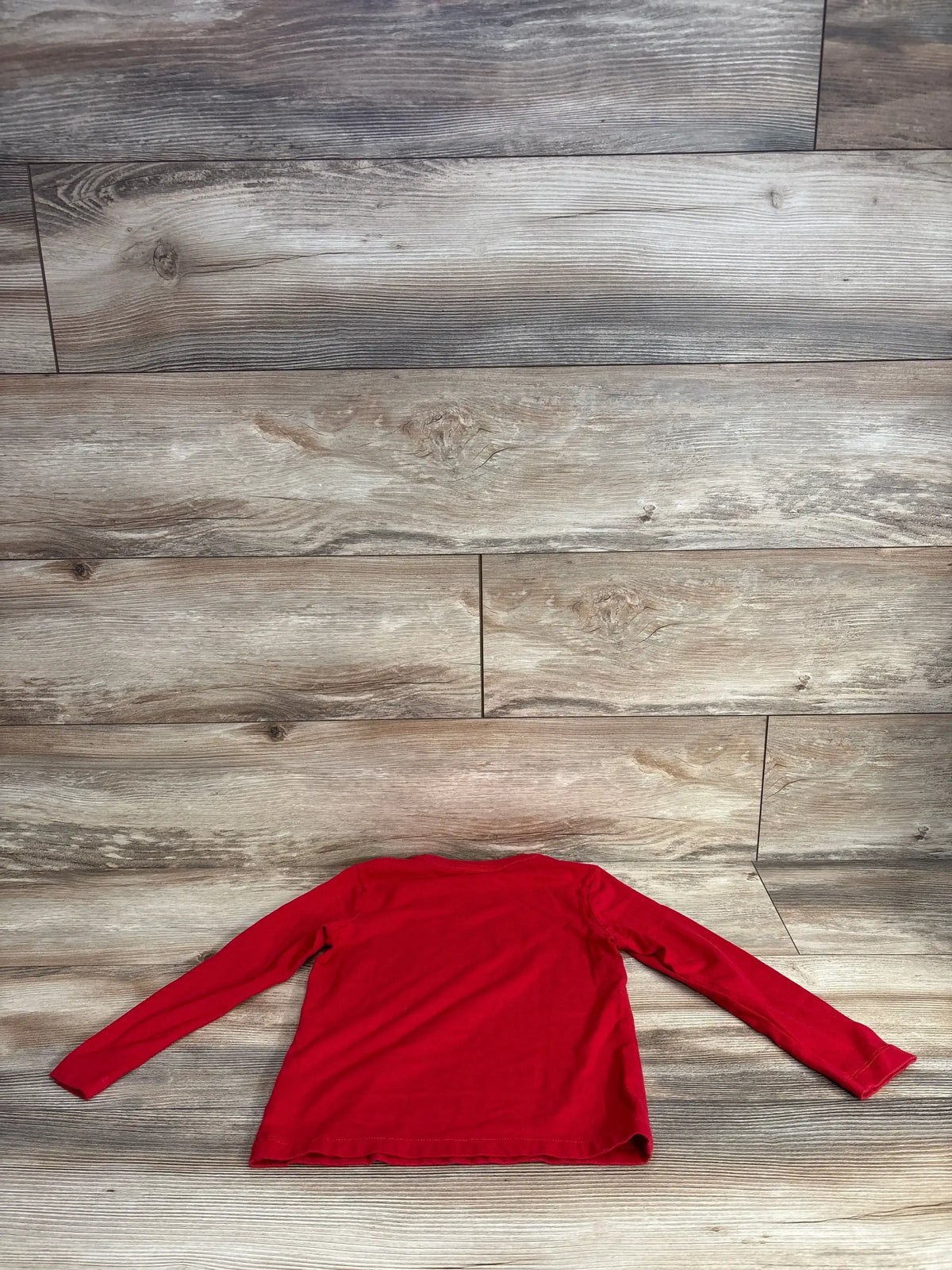 Red long sleeve kids shirt on wood floor, kids clothing resale
