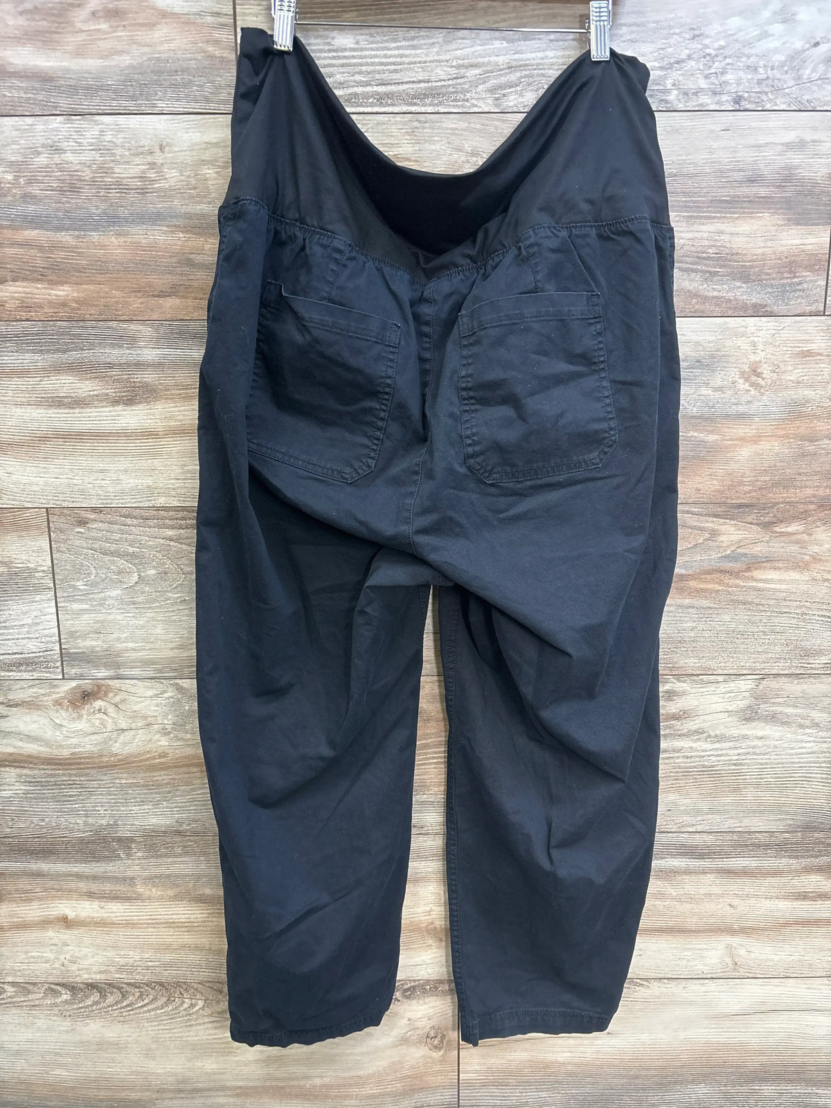 Back view of Old Navy maternity pants in black, size XL, on a wooden background