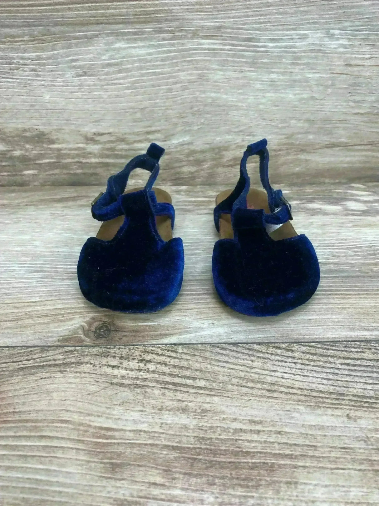 Front view of Baby B’gosh velvet cork baby sandals showcasing T-strap and buckle on wood floor