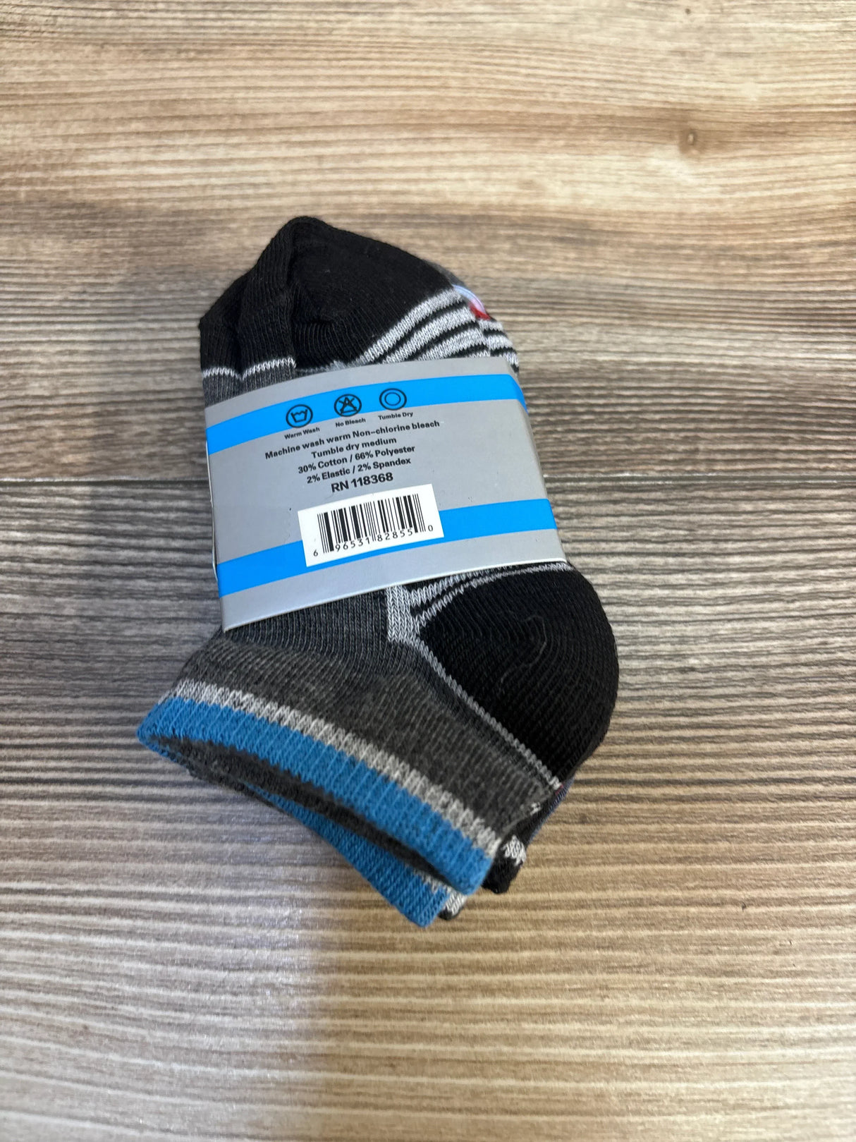 Angled view of NEW Step Up Pattern Socks 3pk (size 2-3) showing folded blue, black, and gray striped toddler socks on wood background