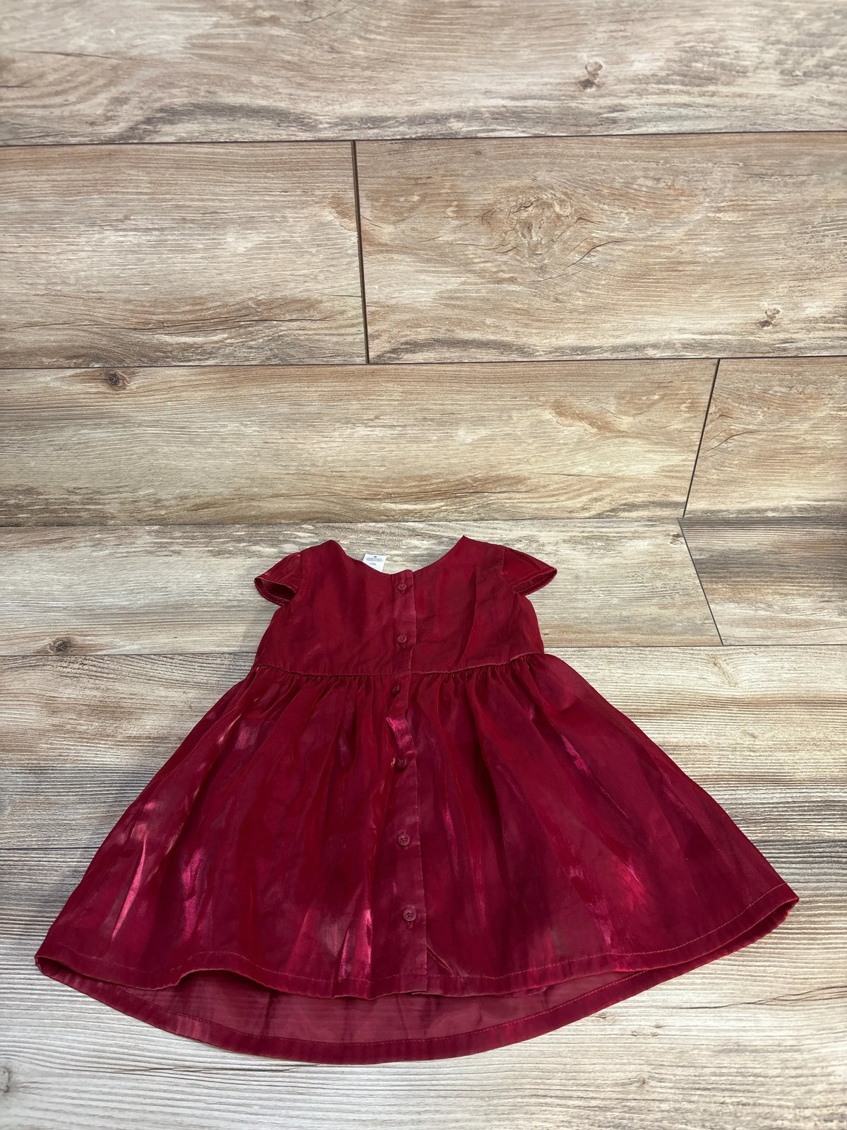 Red satin short-sleeve baby girl dress by Me n Mommy To Be on a wooden background