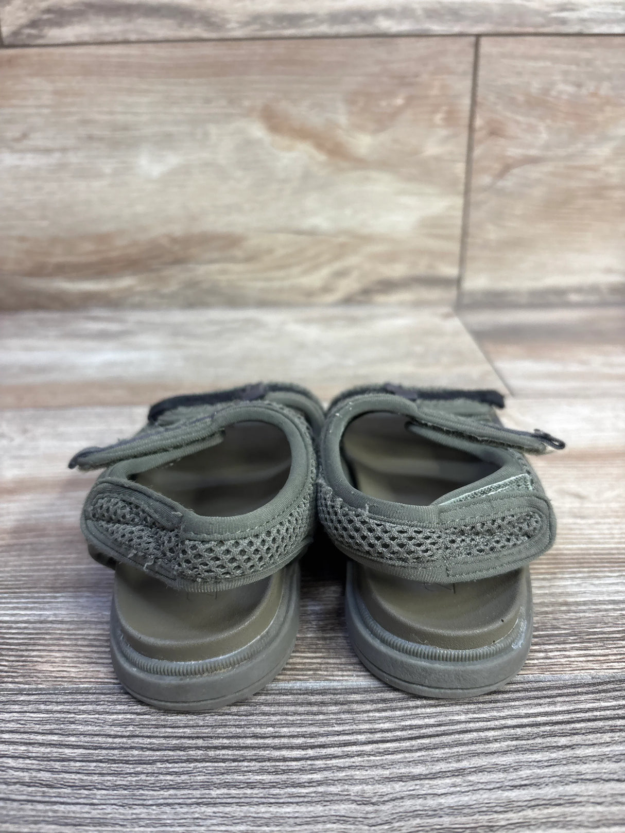 Rear view of Zara Scuba toddler sandals in green, size 7C, showing heel straps and mesh uppers on wood-grain floor