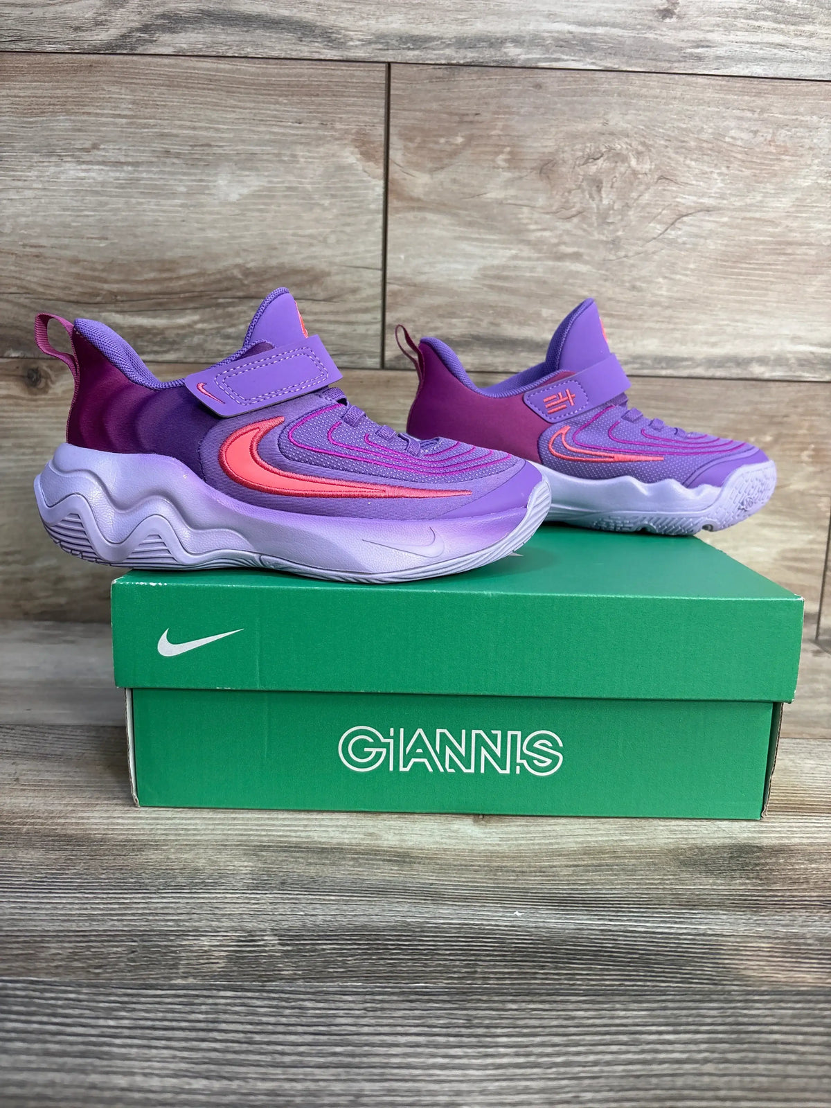 Side view of Nike Giannis 4 PS Black Raspberry sneakers, purple-pink upper with velcro strap on green GIANNIS box