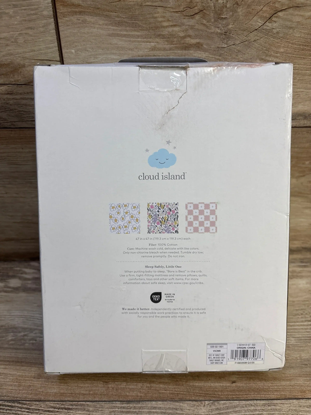 Back of NWT Cloud Island 3pk muslin swaddle blanket package in painterly floral showcasing print swatches and 47x47 size on wood background