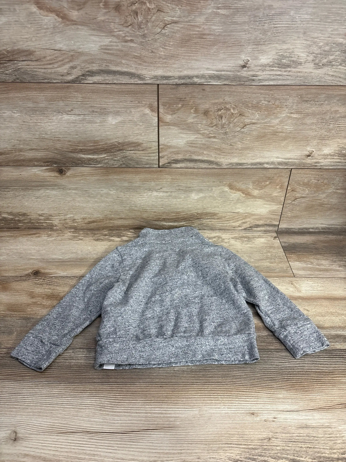 Back view of Baby Gap 1/4-zip pullover jacket in heather gray for 3T showing knit texture on wood background