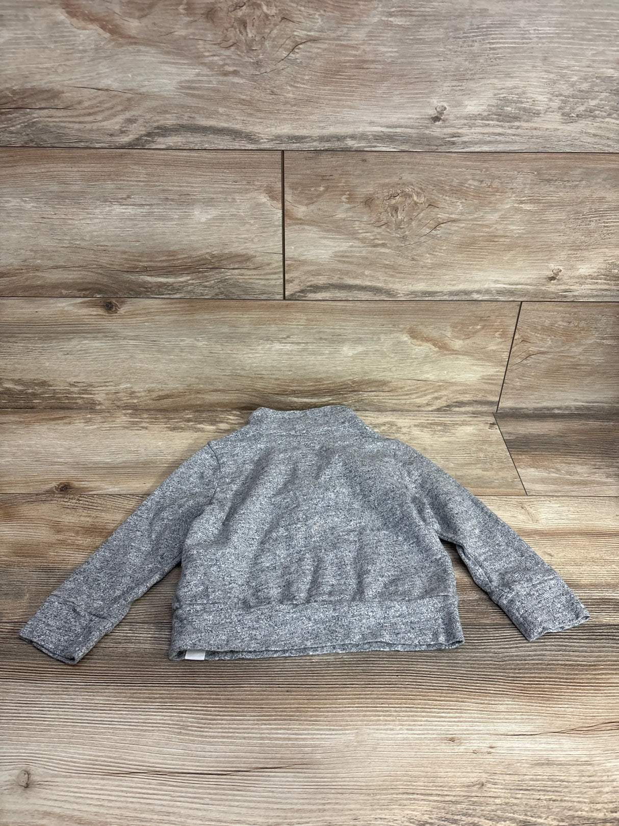 Back view of Baby Gap 1/4-zip pullover jacket in heather gray for 3T showing knit texture on wood background