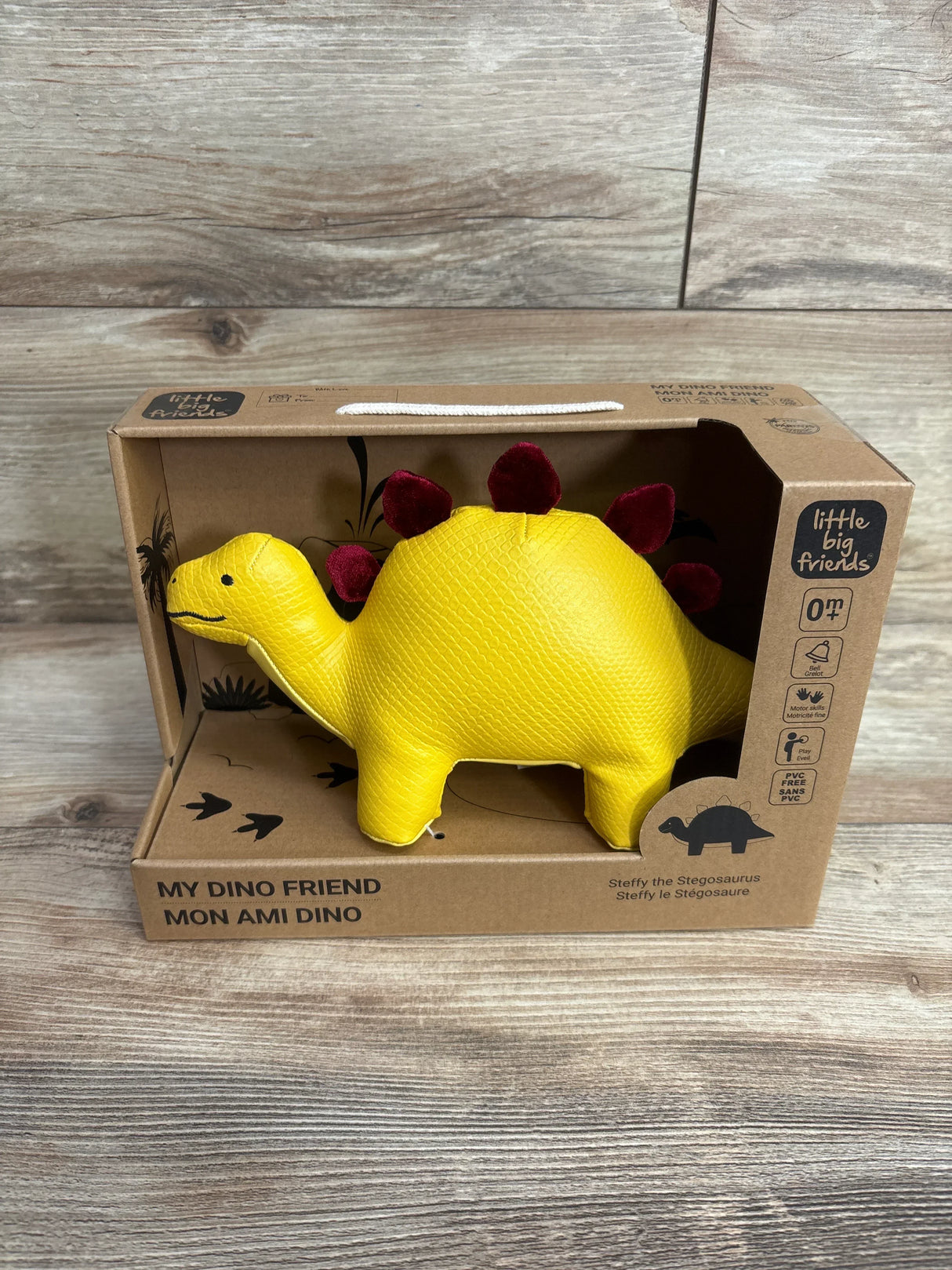 Front view of Steffy the Stegosaurus toy showcasing yellow textured scales and burgundy crest in its cardboard box