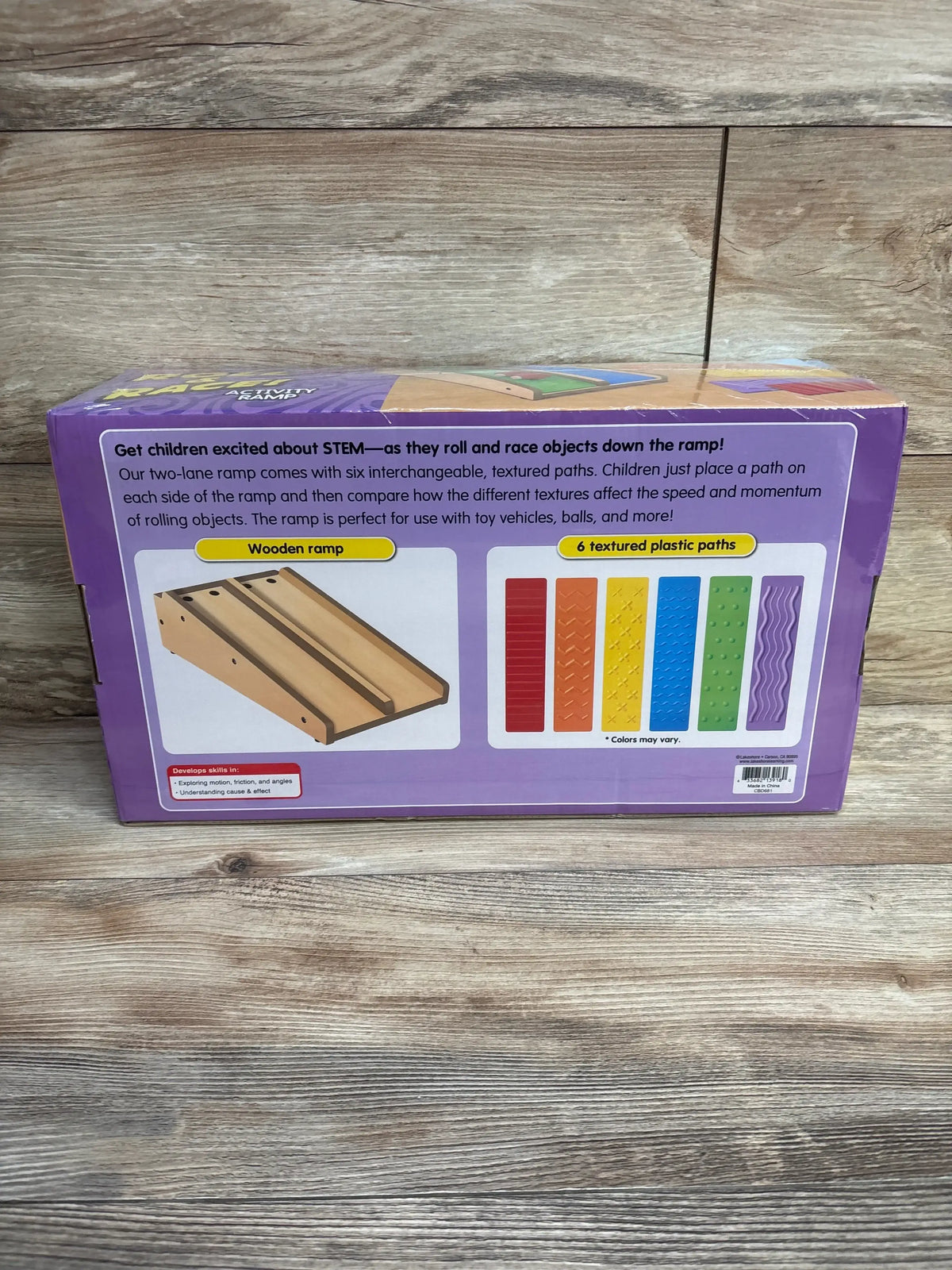 Back of Lakeshore Roll and Race Activity Ramp box showing wooden two-lane ramp and six textured colored paths on wood floor