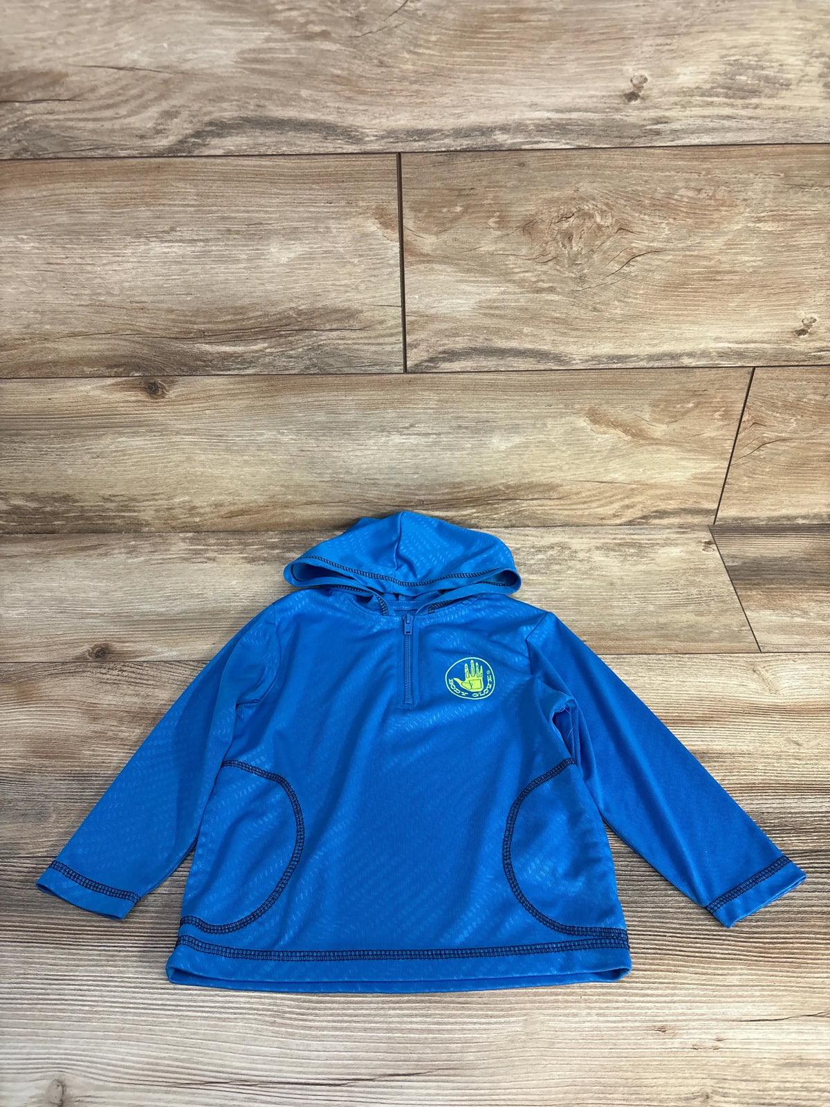 Front view of Body Glove blue hooded quarter-zip rash guard shirt with long sleeves on a wood background