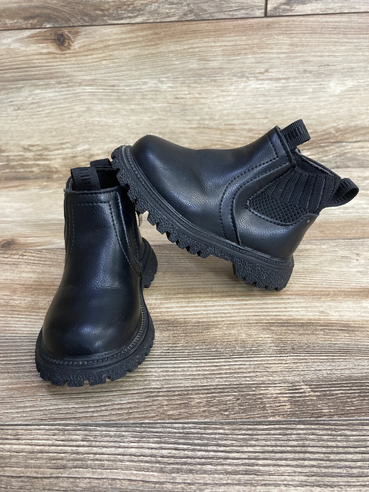Black toddler Chelsea boots with lug soles on wood floor