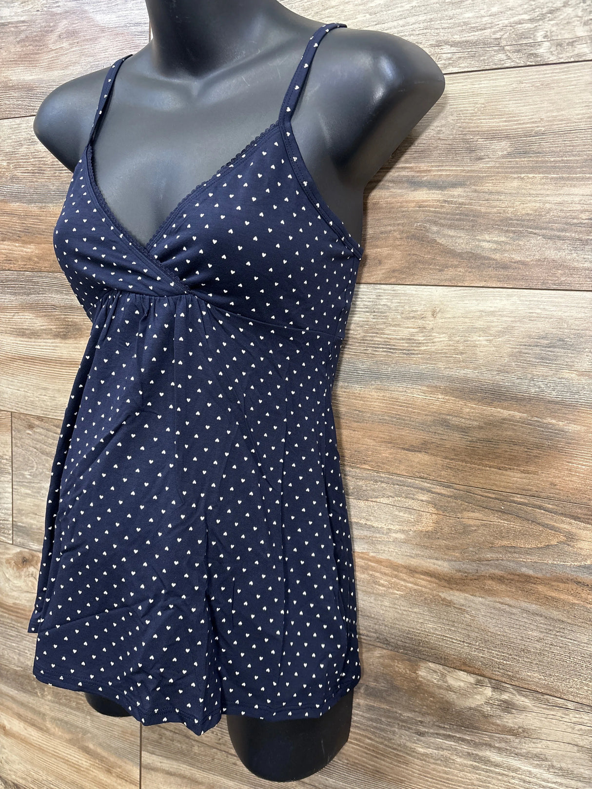 Navy blue maternity tank top with small white heart pattern on black mannequin torso