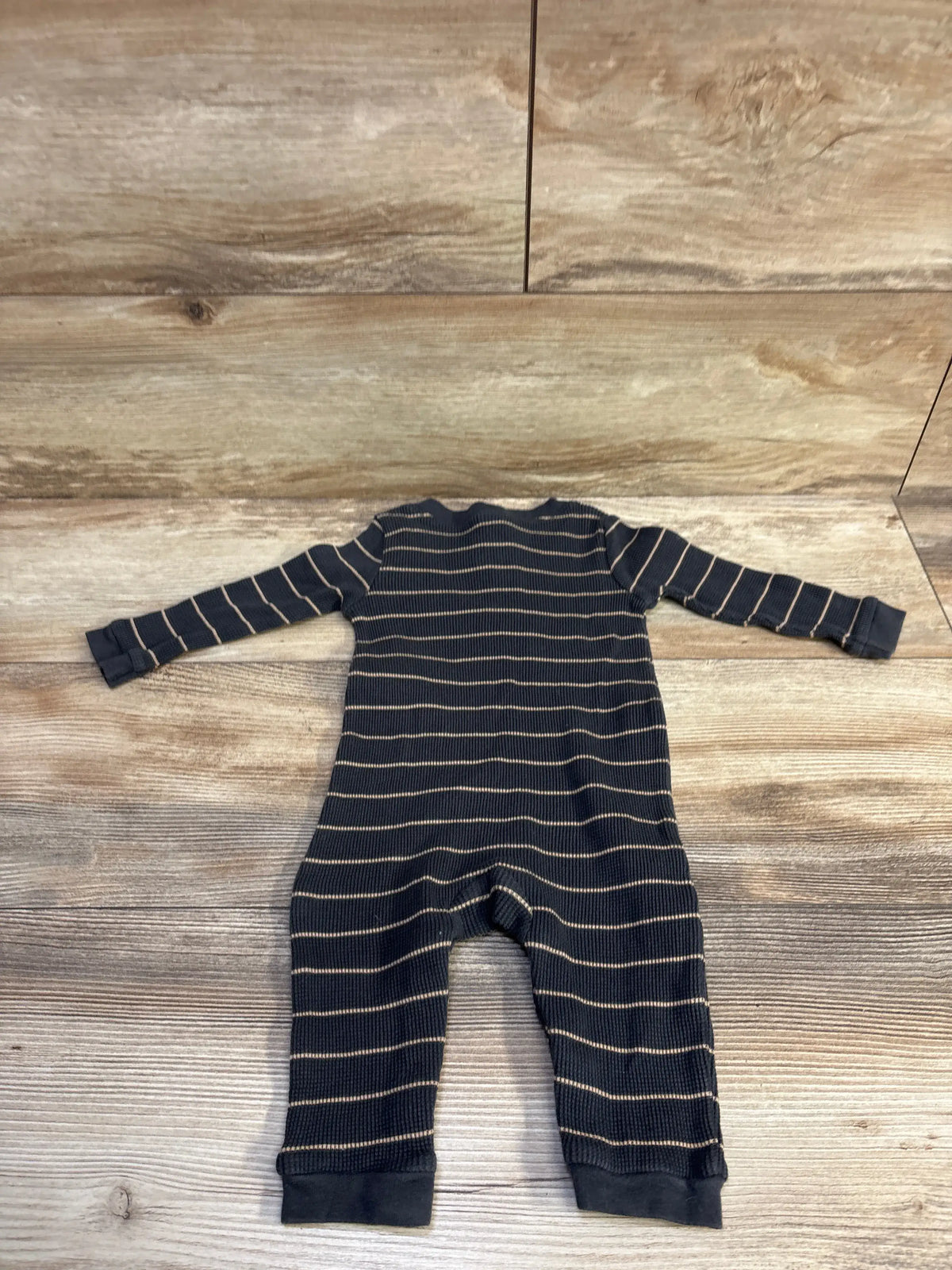 Top-down view of Old Navy Henley Waddle knit coverall showcasing long sleeves and horizontal stripes on a wood surface