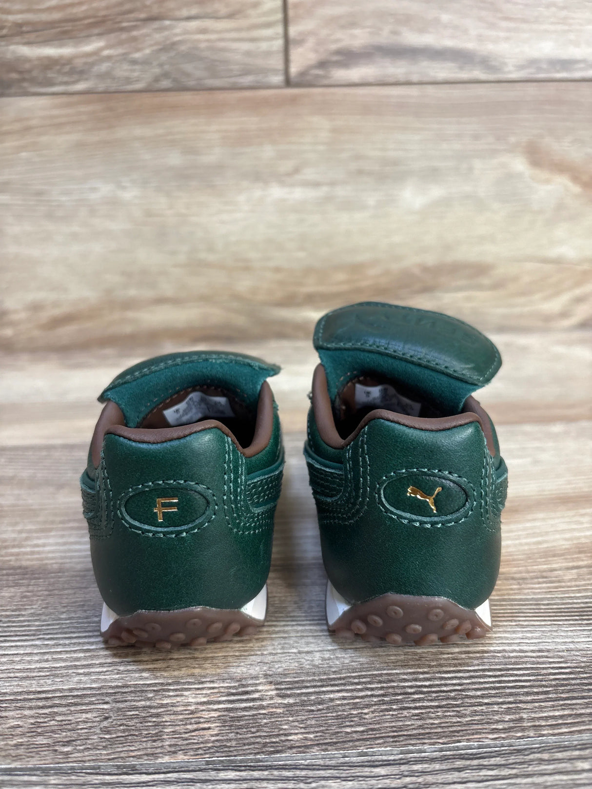 Green Puma baby sneakers with gold logo, soft sole, ideal for infants and toddlers
