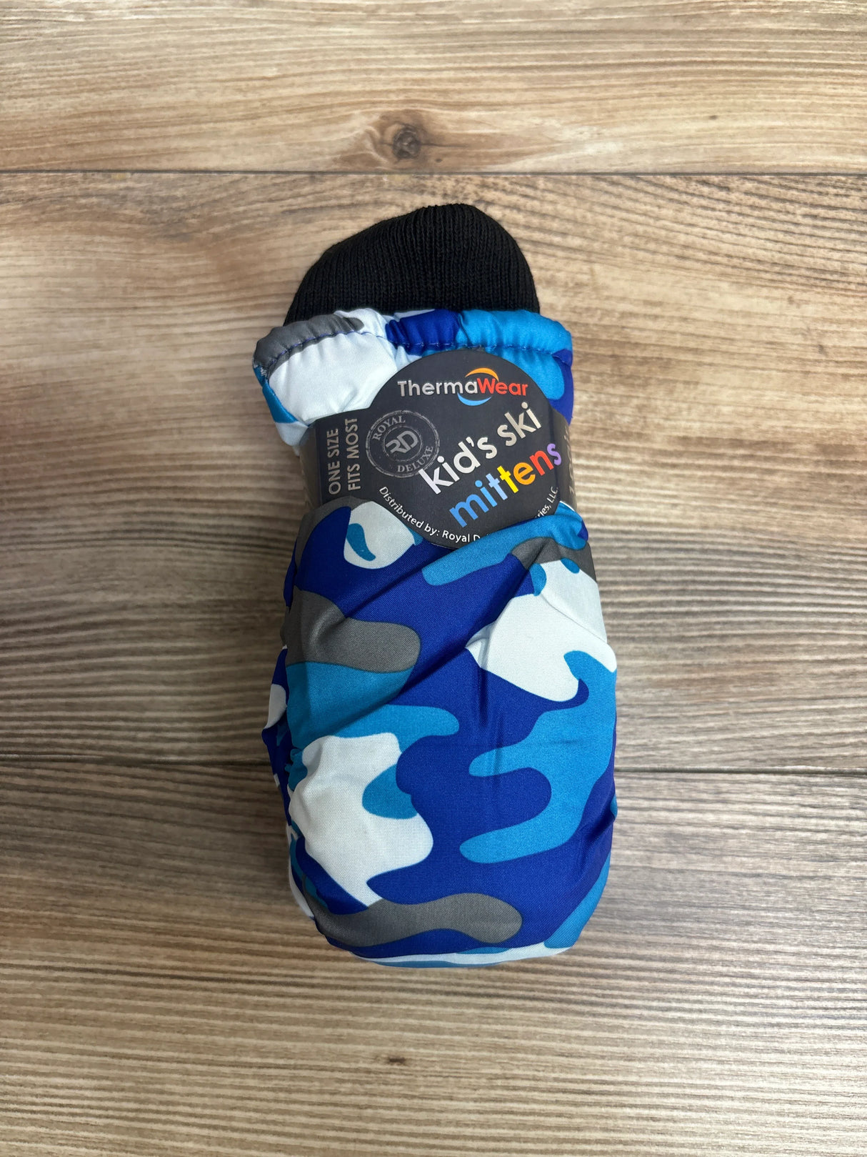 Blue and gray camo kids ski mitten by ThermaWear with black cuff on wooden surface
