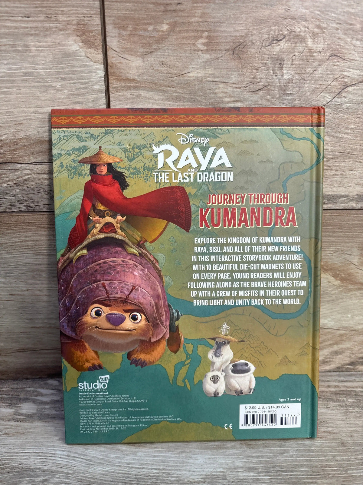 Back cover of Raya and the Last Dragon magnetic hardcover book showing illustrated characters and adventure text on wood
