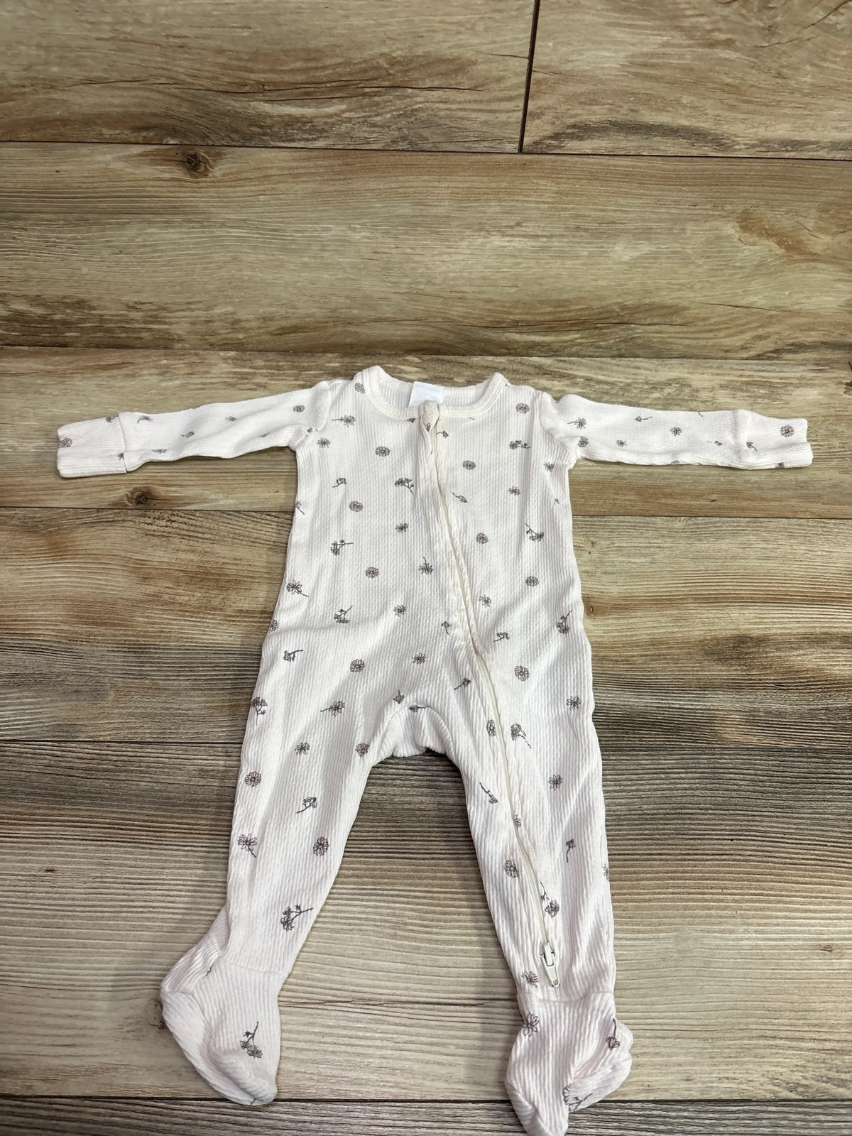 Ivory organic cotton baby sleeper with small floral print and zipper closure
