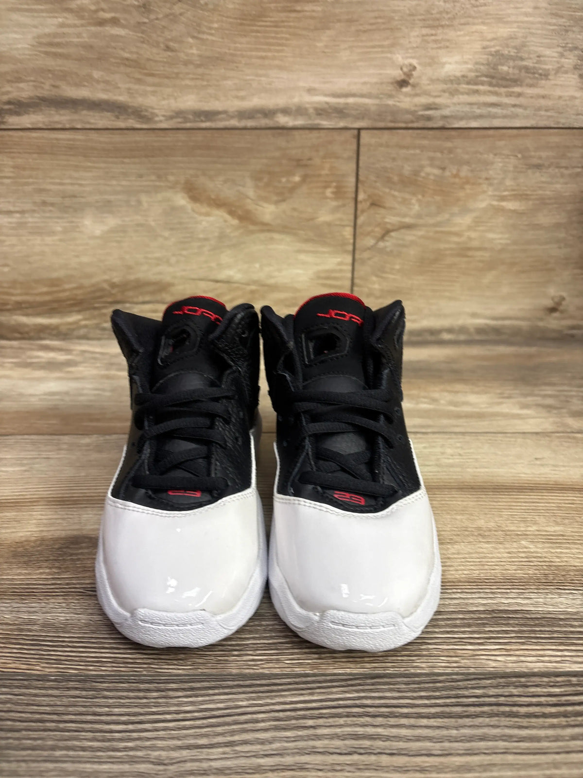 Front view of Air Jordan B’Loyal PS sneakers in White Gym Red, showing black uppers, white toes, and red accents