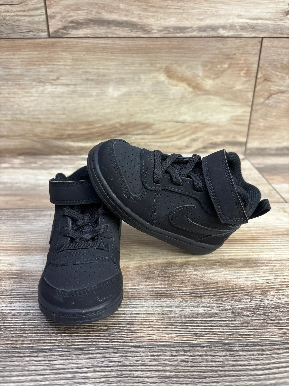 Front and side views of Nike Court Borough Mid TD Triple Black sneakers showcasing perforations, laces, and hook and loop straps