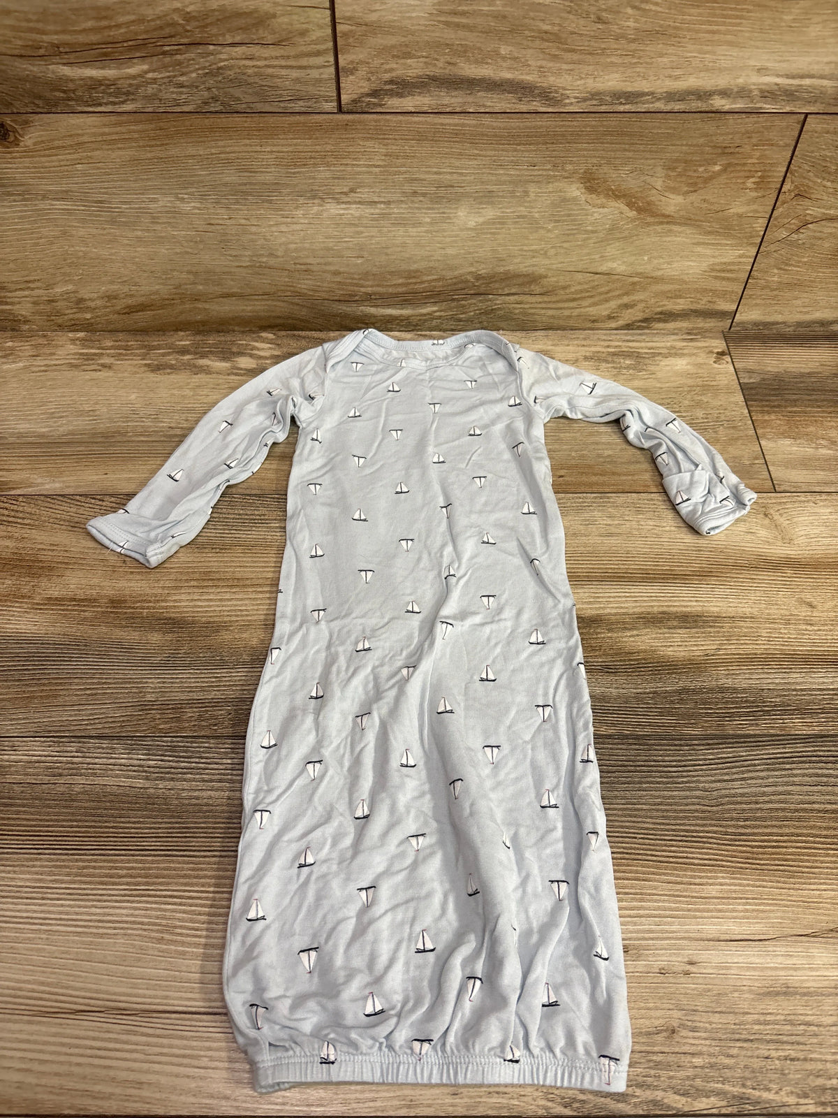 Flat lay of Carter’s PurelySoft blue sleep gown showcasing long sleeves, sailboat print, and gathered hem on wood flooring