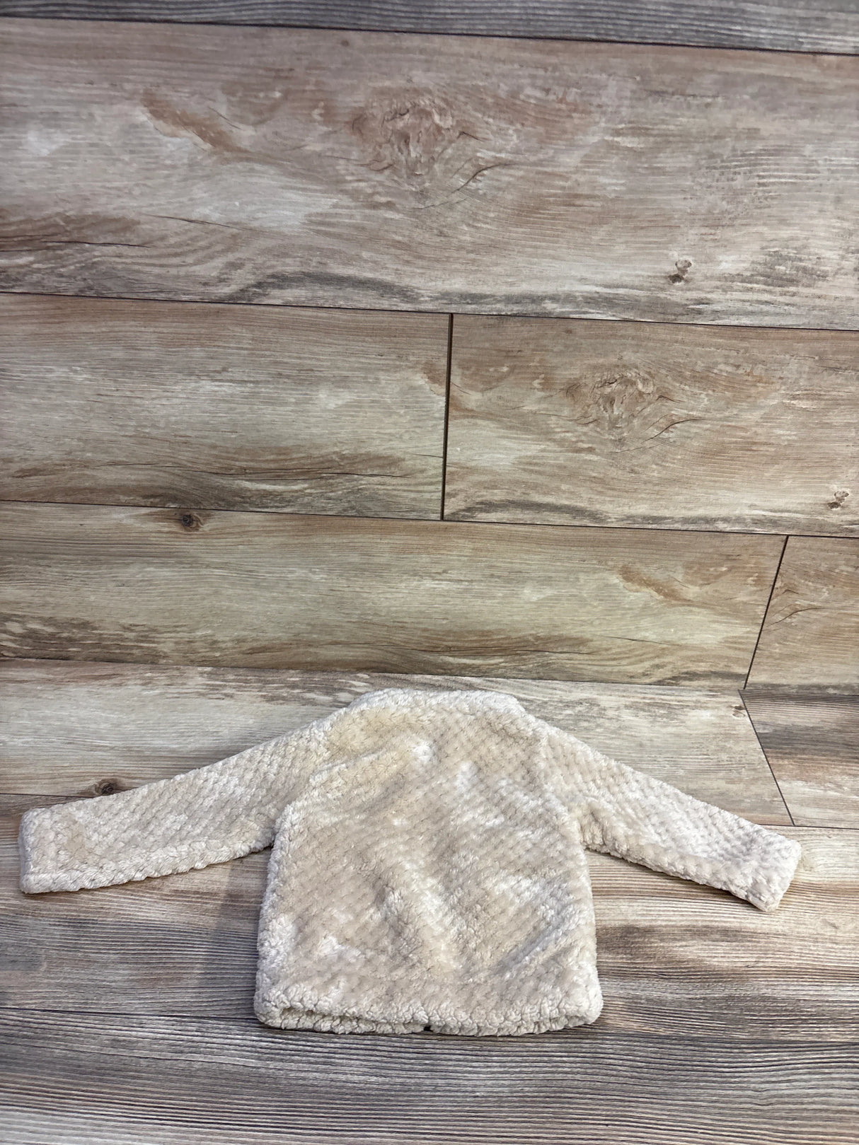 Back view of Columbia Fire Side Sherpa full-zip baby jacket showcasing beige sherpa texture and long sleeves on wood plank background