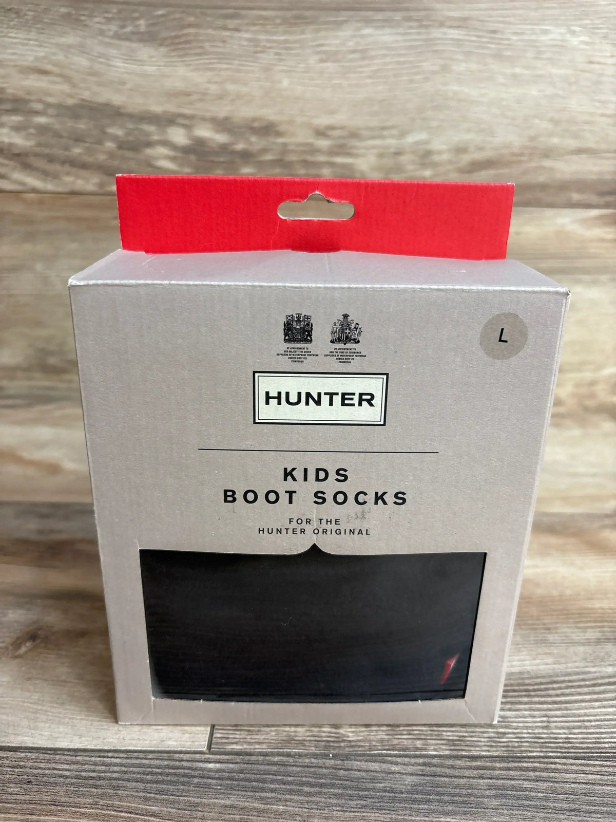 Hunter kids boot socks in original packaging, size large, on wood background