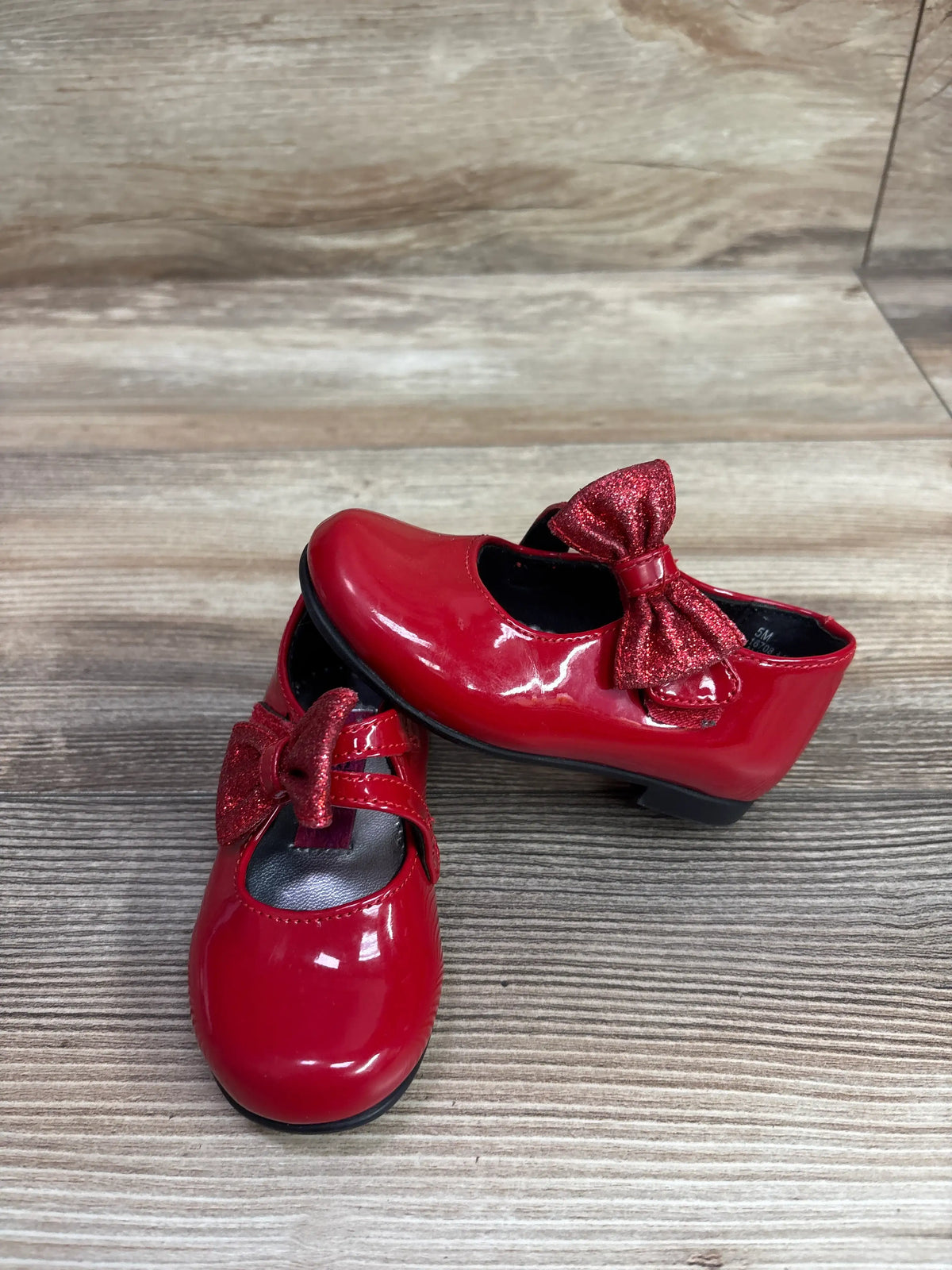 Front and side views of Rachel Shoes Lil’ Molly Mary Jane Bow Flats showcasing glossy red finish and glitter bows