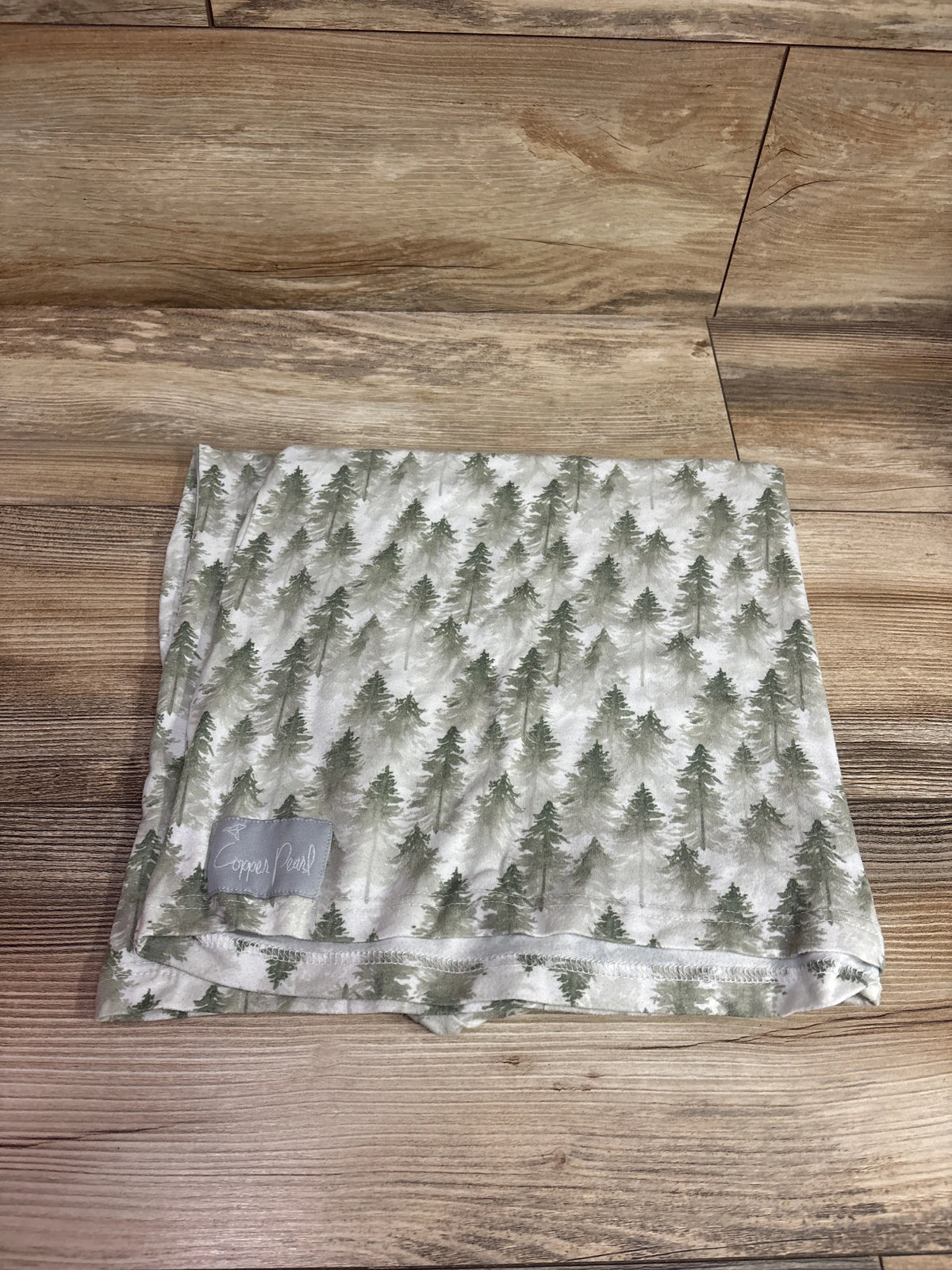 Copper Pearl stretchy 5-in-1 multi-use cover with a grey and green pine tree print