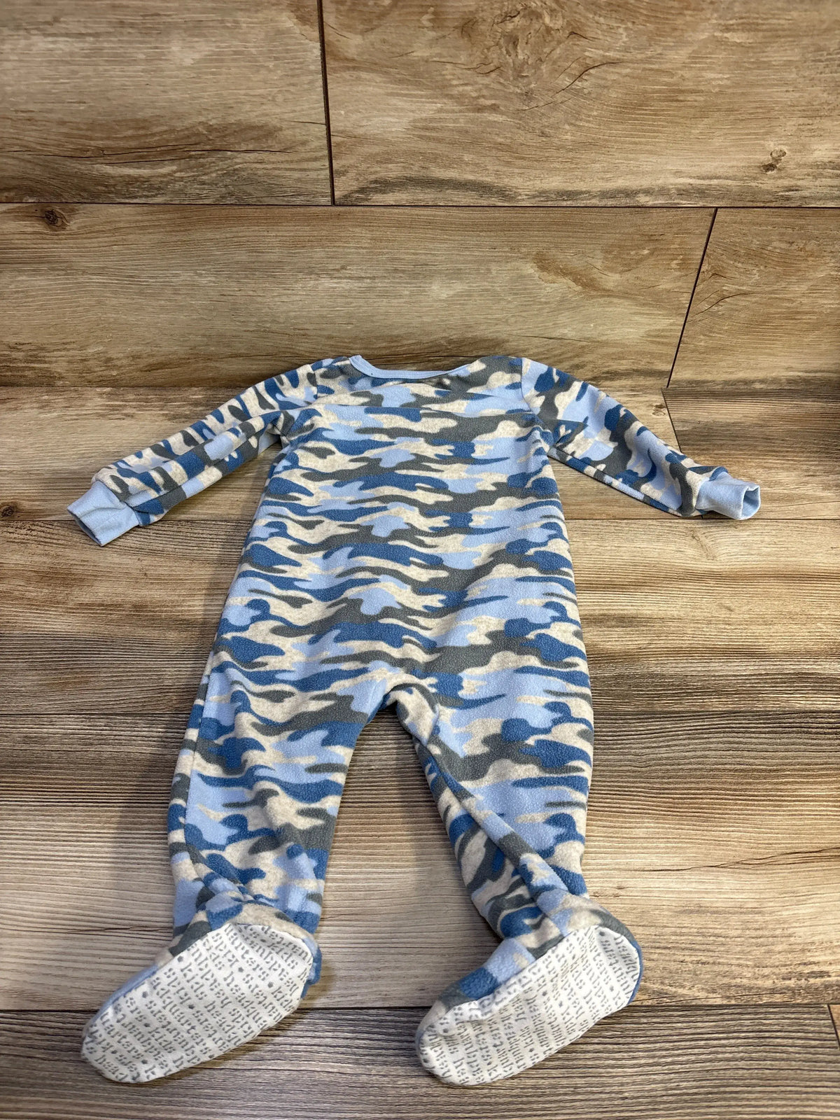 Front view of Kids Headquarters blanket sleeper showcasing blue camouflage print, long sleeves, and attached feet on a wood-look floor