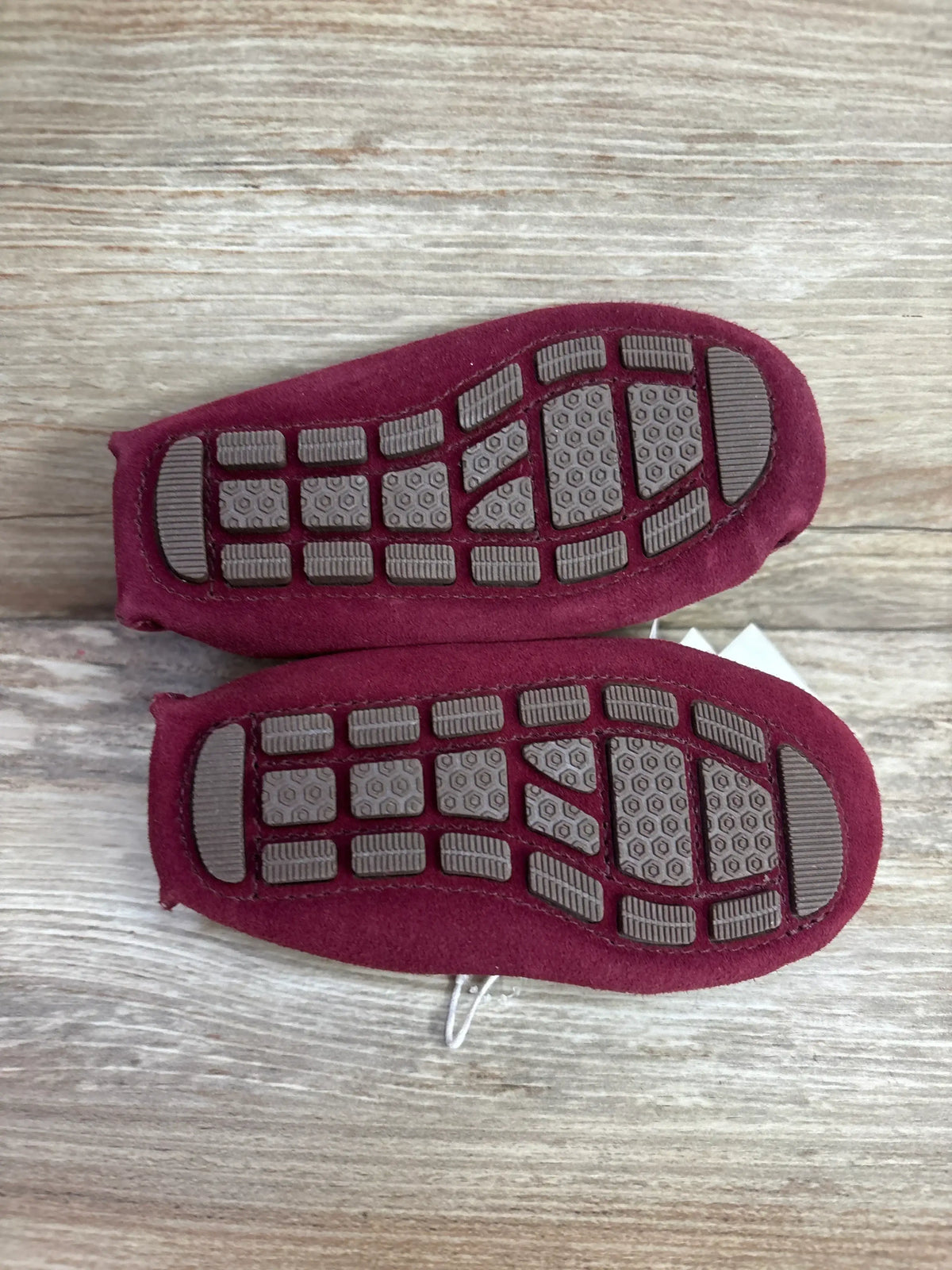 Top-down view of Janie & Jack maroon suede driving shoes size 6C showing brown textured rubber driving soles on wood background