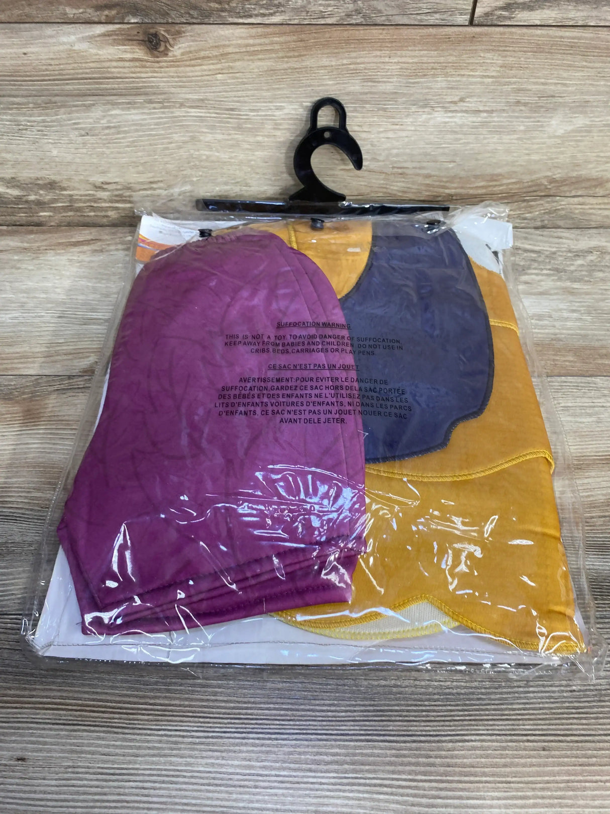 Front view of Beat Bugs Buzz costume showcasing purple, yellow, and navy panels in clear packaging on a wood surface