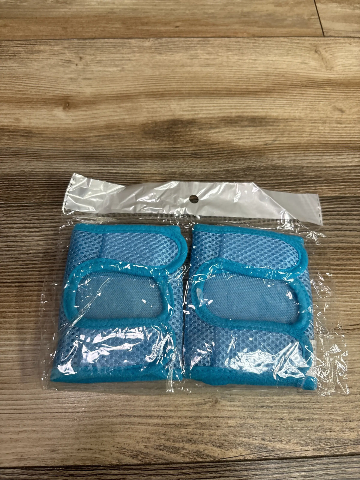 New Lipfer baby crawling knee pads in blue, packaged in clear plastic on a wooden surface.