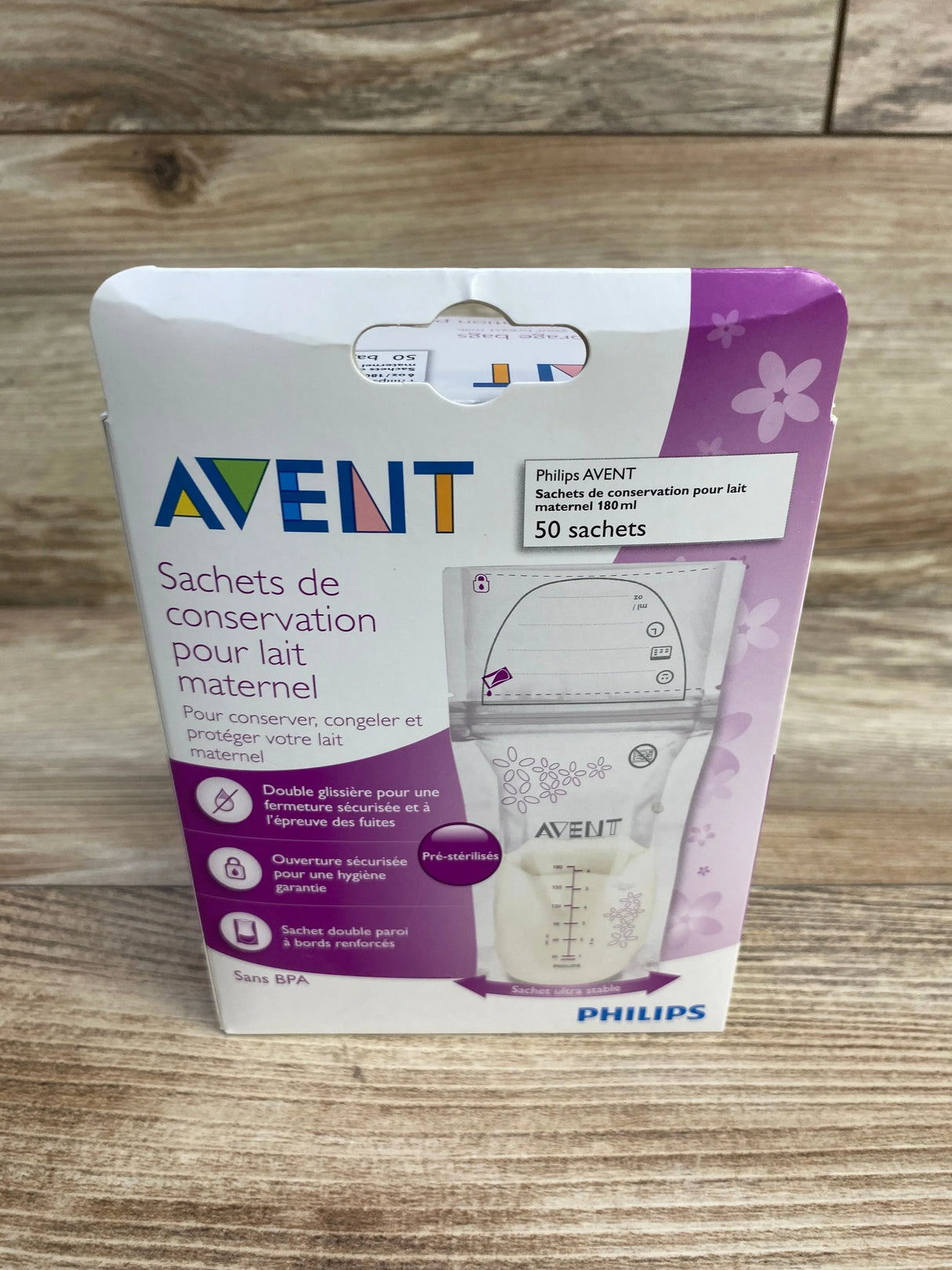 Front of AVENT breast milk storage bags box (50 x 6 oz) showing bag image with measurement marks and double-zipper on wood