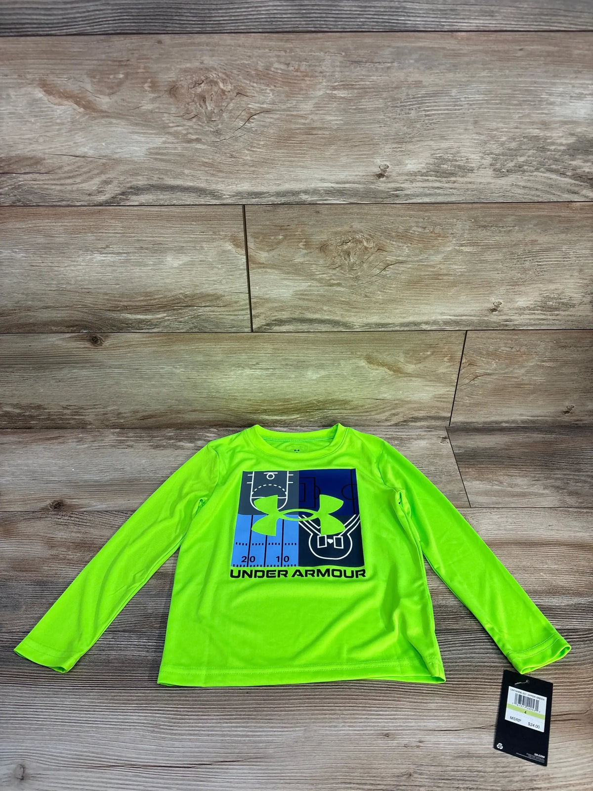 Front view of boys' Under Armour long-sleeve performance shirt in hyper green with blue logo and field graphic on wood background