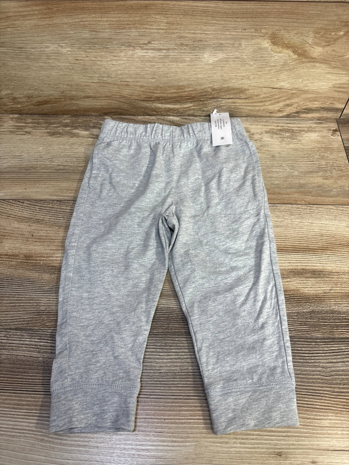 Front view of grey Wonder Nation pull-on jersey joggers showcasing elastic waistband and cuffed legs on a wood surface