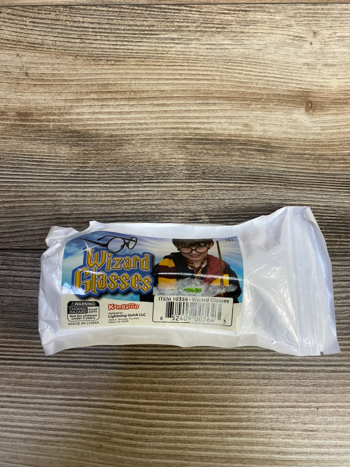 Packaged wizard glasses costume accessory with label and image of child in wizard outfit on wood surface