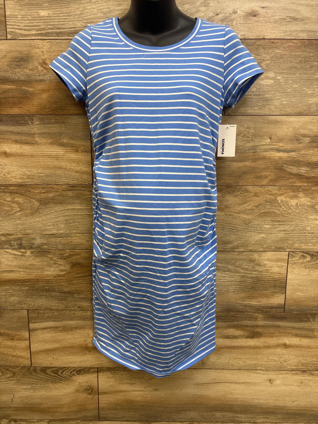 Front view of Sonoma maternity striped dress showing short sleeves and side ruching on black mannequin with wood background