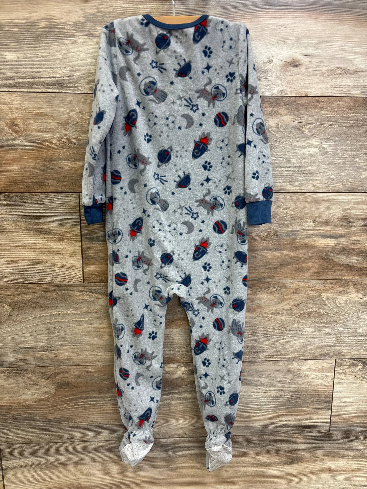 Grey fleece footed baby pajamas with space and animal print, long sleeves, on wooden background